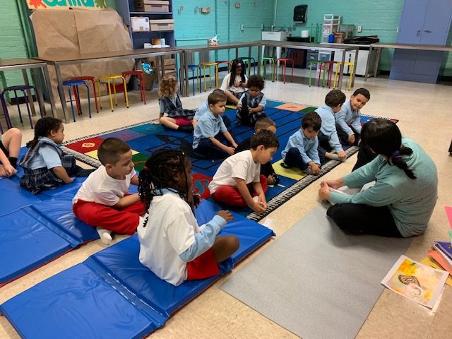 Teacher with kids in circle time at after-school Spanish class