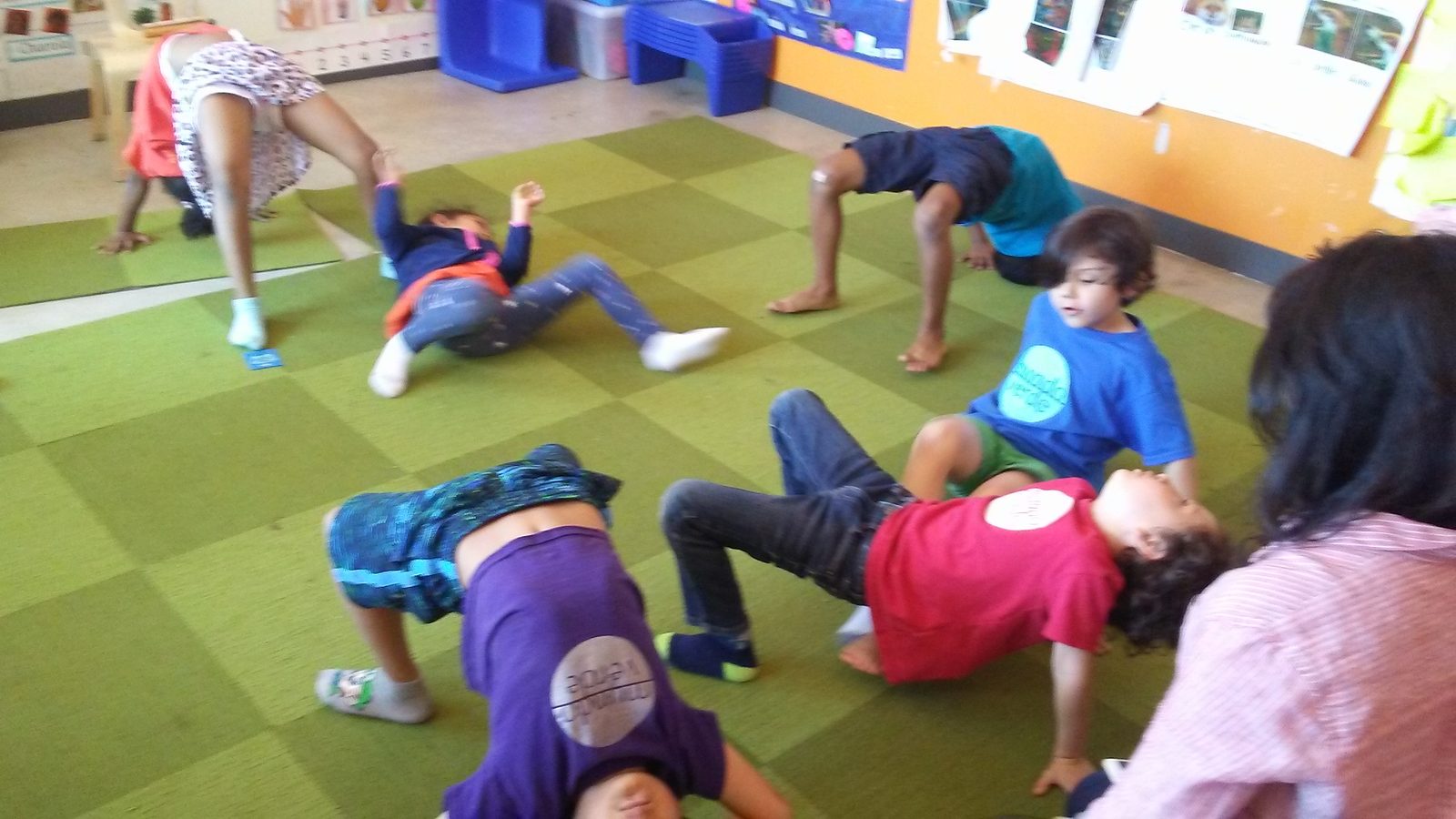 Children doing yoga poses in Spanish class