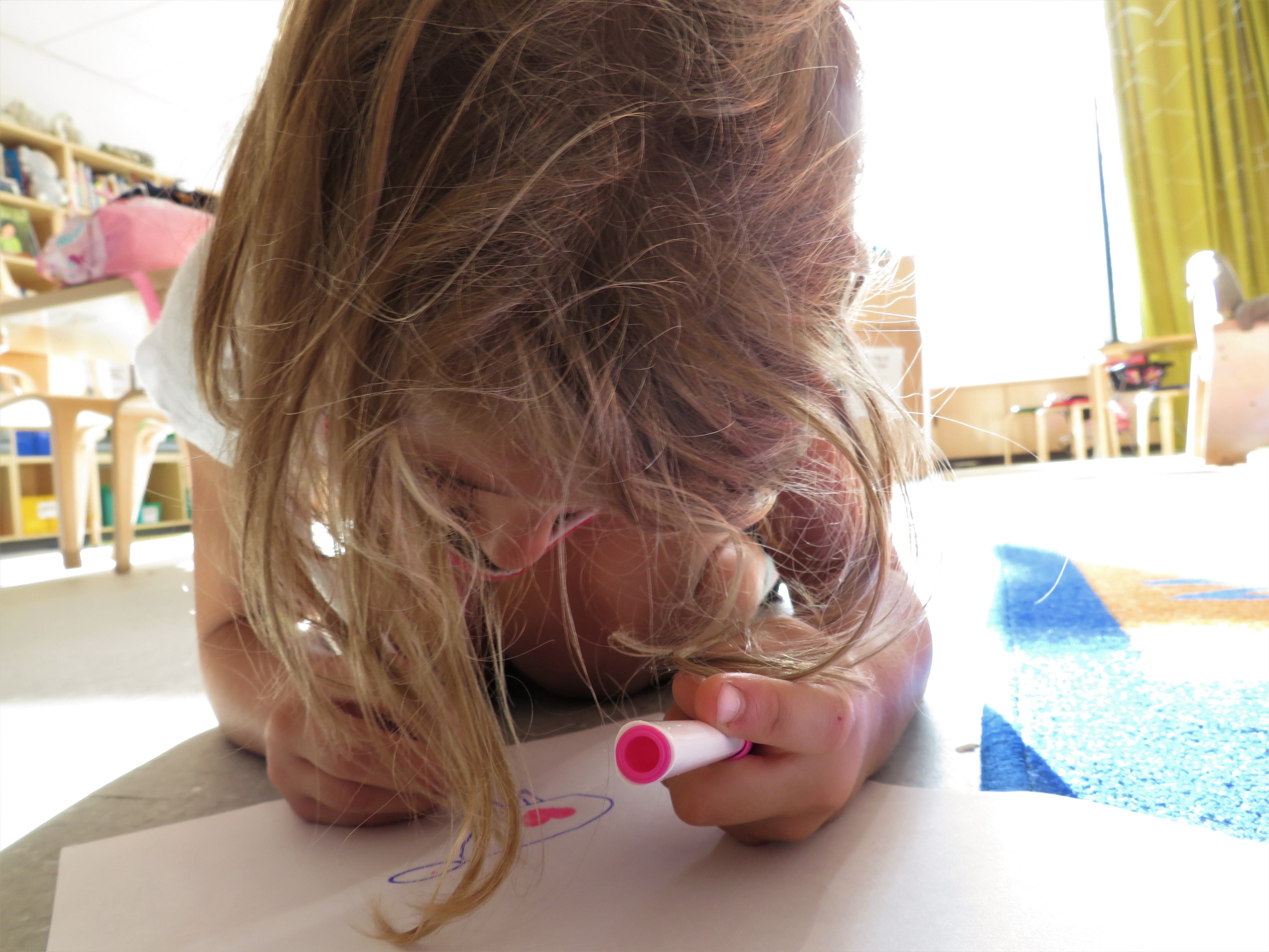 Girl drawing on the floor during Spanish class